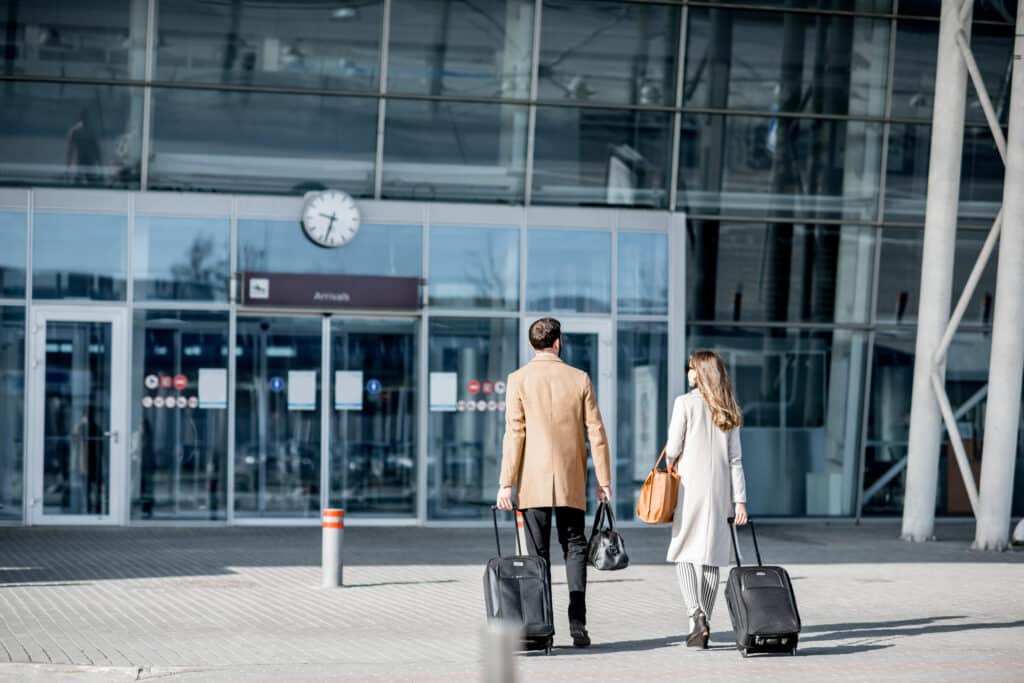 Travellers walking into an airport terminal
